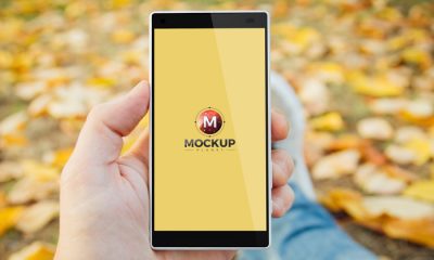 Man-in-Park-Holding-Smartphone-Mockup-Free-Psd