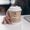 Free-Person-Holding-Kraft-Coffee-Cup-Mockup-Design
